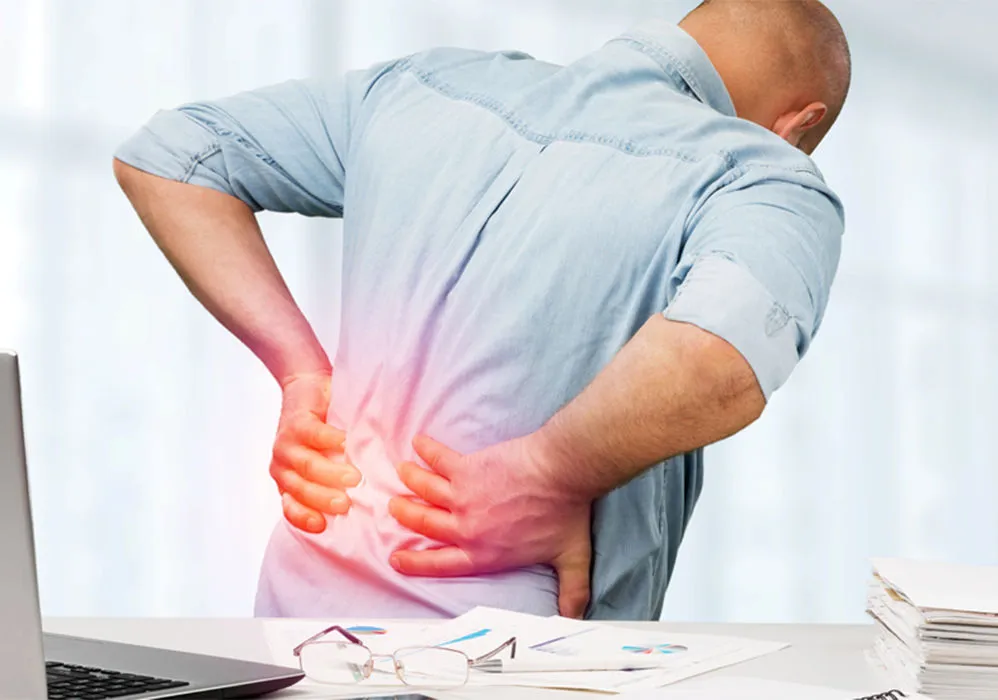 Man with lower back pain holding his back.