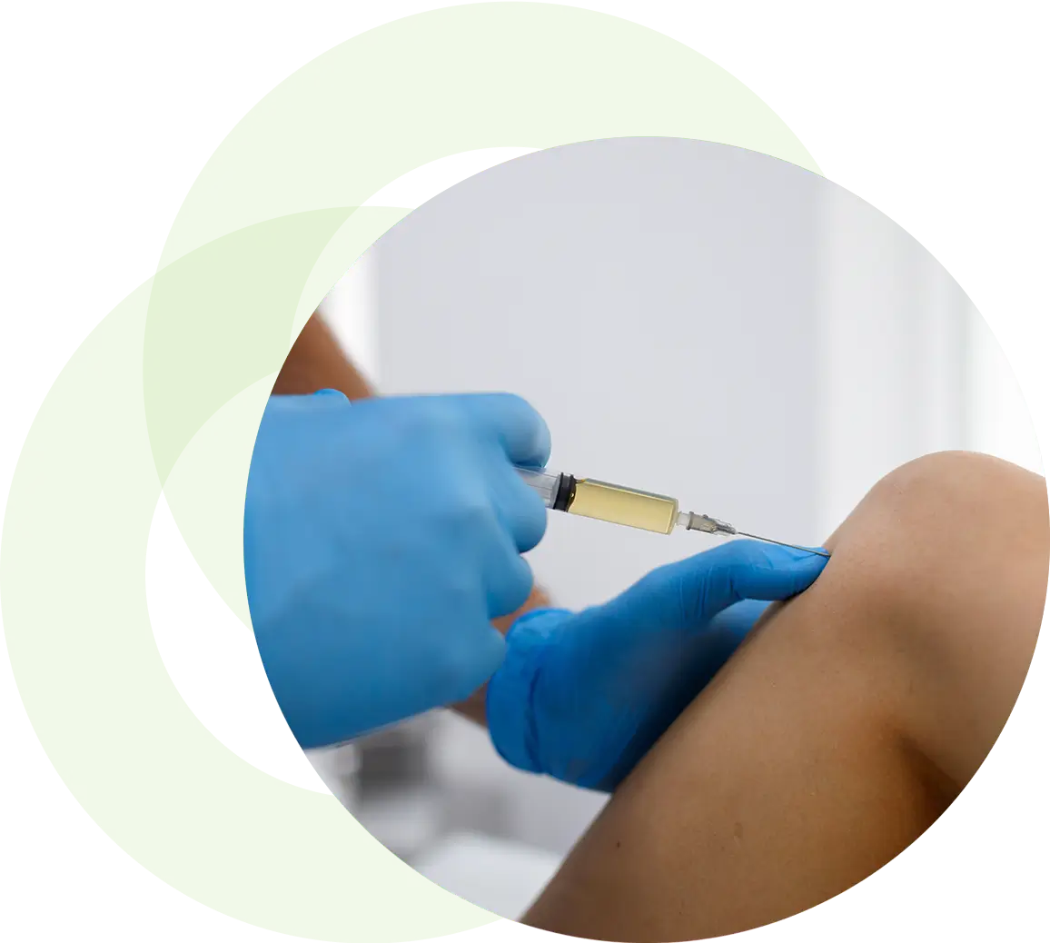 A gloved hand injecting a knee.